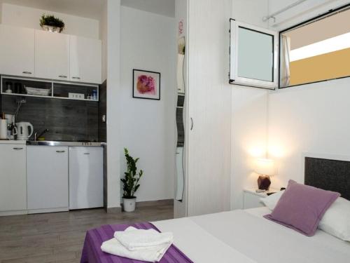 Apartment Onyx في سبليت: غرفة مع مطبخ وسرير في غرفة