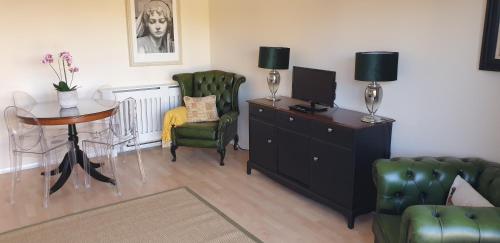 a living room with a desk and a chair and a table at Rainbow on Sea Frinton-on-Sea in Kirby Cross