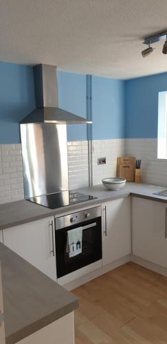 a kitchen with a stove top oven in a kitchen at Rainbow on Sea Frinton-on-Sea in Kirby Cross