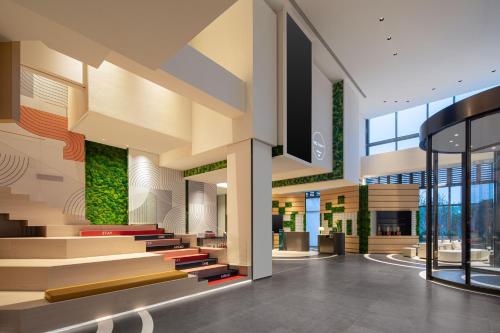 a lobby of a building with stairs and plants at EVEN Hotel Shanghai Hongqiao CBD by IHG in Shanghai