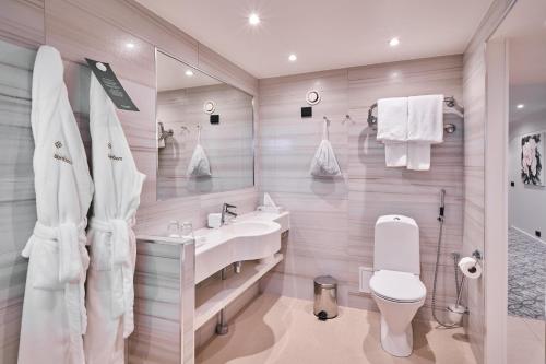 a white bathroom with a sink and a toilet at Naantali Spa Hotel in Naantali
