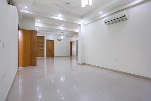 an empty room with white walls and a white tile floor at FabHotel New Journey Hospitality Near MG Road & Sikanderpur Metro in Gurgaon