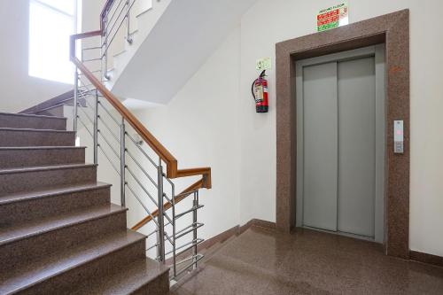 a set of stairs with a door in a building at FabHotel New Journey Hospitality Near MG Road & Sikanderpur Metro in Gurgaon