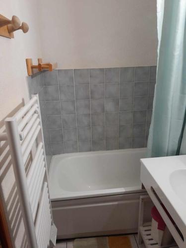 La salle de bains est pourvue d'une baignoire et d'un rideau de douche. dans l'établissement 2 pieces Morzine, à Morzine