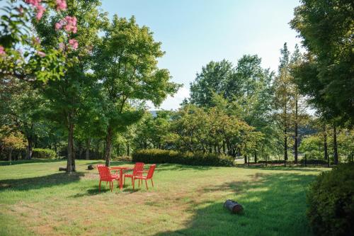 four red chairs and a table in a park at Kinock in Gyeongju