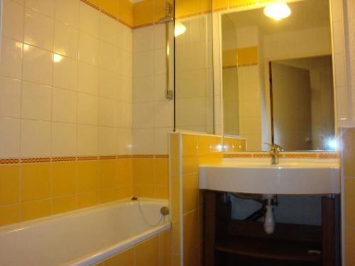 une salle de bain avec un lavabo, une baignoire et un miroir dans l'établissement Résidence Plan Du Lac - PLAN DU LAC 308 MAE-4421, à Les Allues