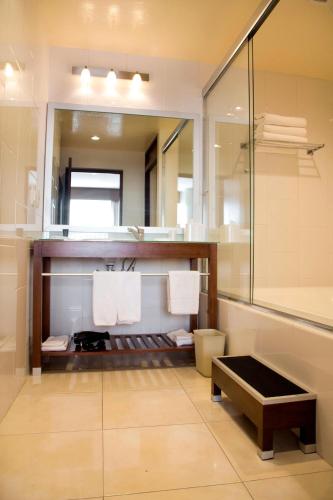 a bathroom with a mirror and a bench and towels at Four Points by Sheraton Queretaro Norte in Querétaro