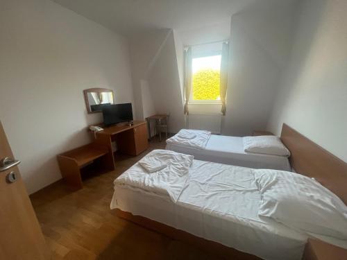 a bedroom with two beds and a desk and a window at Pokoje gościnne Słowiańska Słońsk (restauracja) in Słońsk