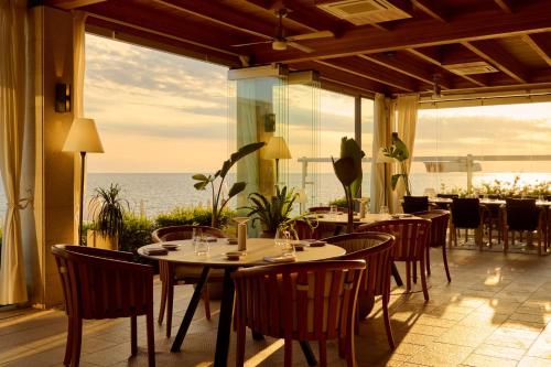 a restaurant with tables and chairs and a view of the ocean at Isabella Island Resort, Valamar Collection in Poreč