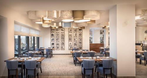 a dining room with tables and chairs and windows at Isabella Island Resort, Valamar Collection in Poreč