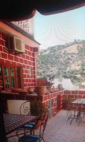 a patio with tables and chairs on a brick building at Kasabah Senhaji in Moulay Idriss Zerhoun