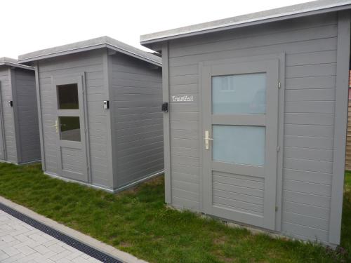a row of grey storage garages on a lawn at Ferienhaus TraumZeit in Pepelow