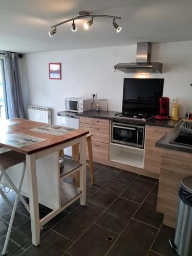 - une cuisine avec une table en bois et une cuisinière dans l'établissement Gite de l écluse, à Sery
