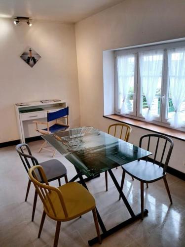 une salle à manger avec une table et des chaises en verre dans l'établissement Gite de l écluse, à Sery