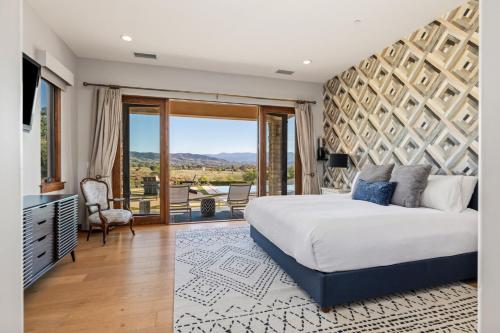 une chambre avec un grand lit et un balcon dans l'établissement Villa de la Sky Ranch Sprawling Tuscan Villa in Wine Country, à Temecula