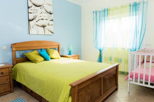 a bedroom with a bed with yellow sheets and a window at Moradia Malhao in Malhão