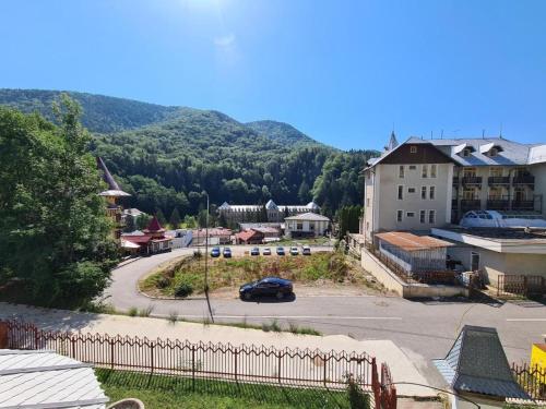 a small town with a car driving down a street at Pensiunea Eurosan Slănic-Moldova in Slănic-Moldova