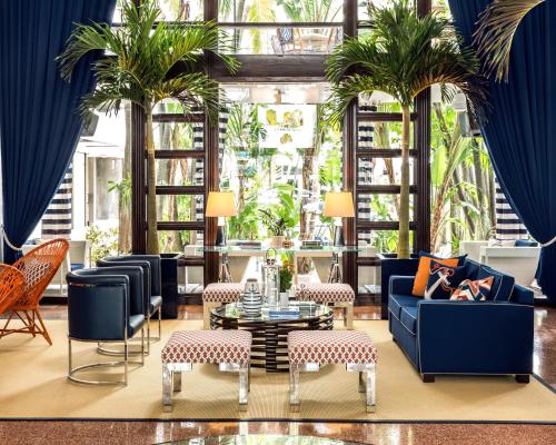 a living room with blue furniture and palm trees at Albion Hotel in Miami Beach