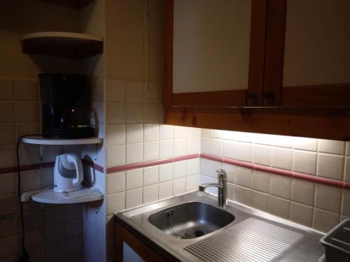 une petite cuisine avec un évier et un comptoir dans l'établissement Résidence Les Glaciers 3 - 3 Pièces pour 7 Personnes 191, à Aime La Plagne