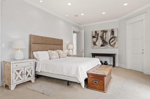 a white bedroom with a bed and a fireplace at Malibu Dunes by Fieldtrip Expansive Hamptons-Style Estate w Private Beach Backyard in Malibu