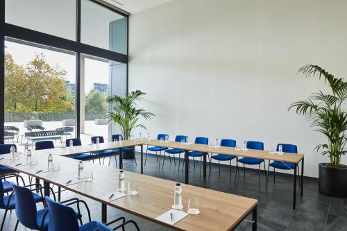a conference room with wooden tables and blue chairs at Four Points by Sheraton Barcelona Airport in Barcelona