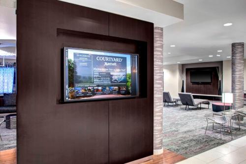 a flat screen tv on a wall in a lobby at Courtyard Richmond North/Glen Allen in Richmond