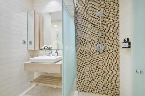a bathroom with a sink and a shower at Arcus by Kozystay - Ancol in Jakarta