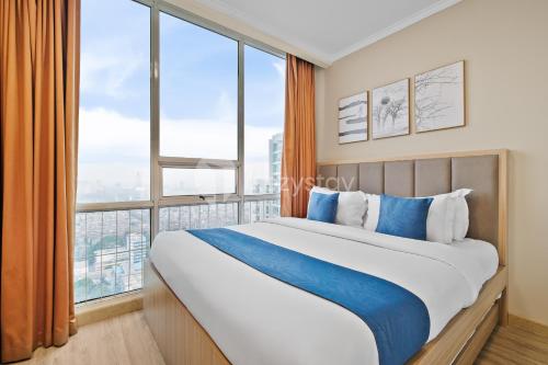 a bedroom with a large bed with a large window at Arcus by Kozystay - Ancol in Jakarta