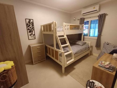 a bedroom with a bunk bed with a ladder at Phala Sunshine Villa in Ban Phala