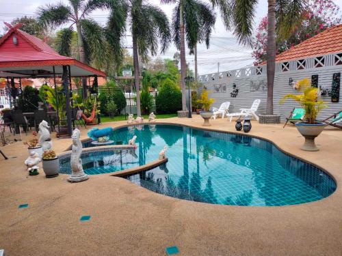 a swimming pool in a yard with palm trees at Phala Sunshine Villa in Ban Phala