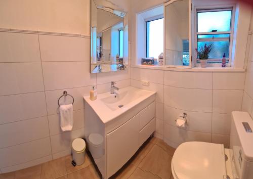 a white bathroom with a sink and a toilet at Dalia's Blue Mountain Retreat in Katoomba
