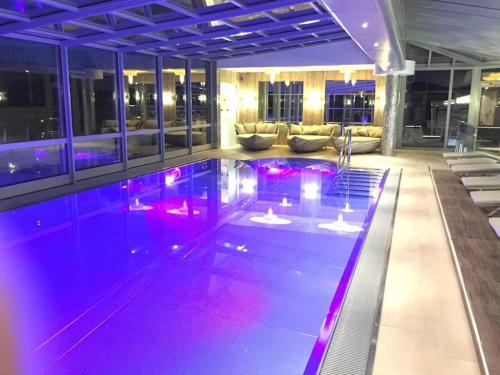 a swimming pool with purple lighting in a building at Wellness & Landhotel Prinz- Wellness & Romantik in Anger