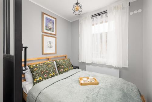 a bedroom with a bed with a tray on it at Apartament Bałtycki Zakątek by Noclegi Renters in Dziwnów