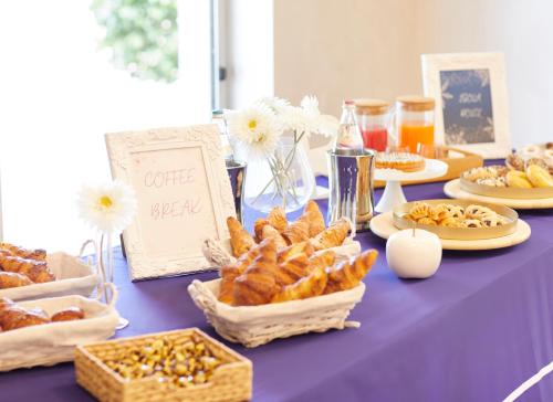 a purple table with food and bread and flowers at Palace Hotel Zingonia in Verdellino