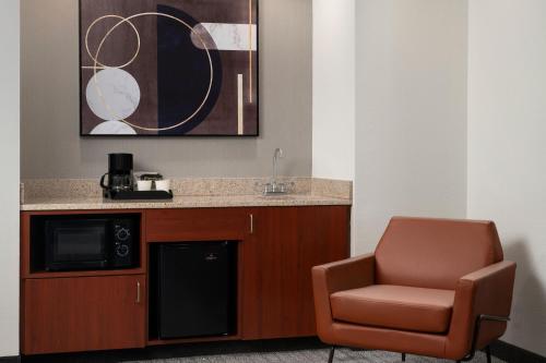 a room with a chair and a counter and a microwave at Courtyard Richmond North/Glen Allen in Richmond