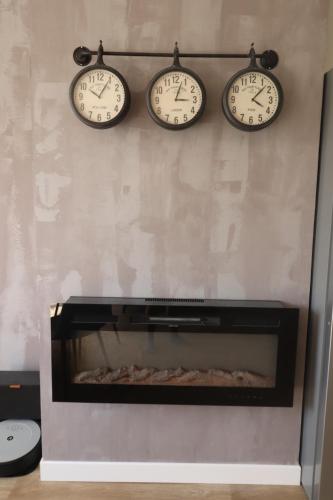 three clocks on a wall above a fireplace at Gite à la campagne 4 étoiles - 200m2 in Sailly