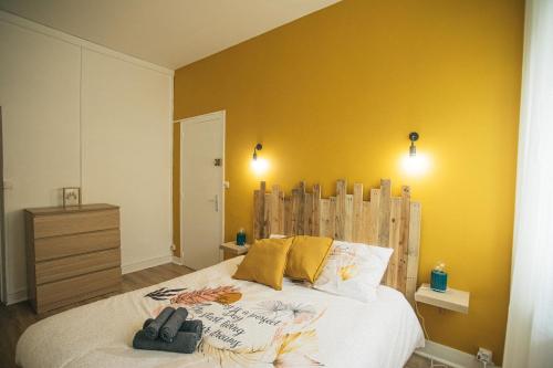 - une chambre avec un grand lit aux murs jaunes dans l'établissement 