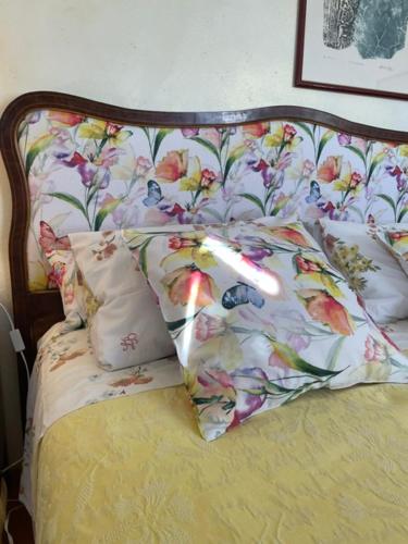 a bed with a floral headboard and two pillows at Fiori Di Maggio in Muscletto