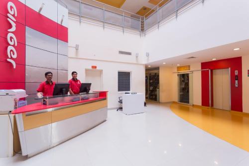 two men standing at a counter in an office lobby at Ginger Pondicherry in Puducherry