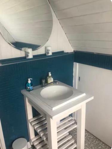 une salle de bain avec un lavabo blanc et un miroir dans l'établissement Maison 7 Pers 15 mn de Lille, à Santes