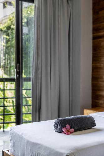 a towel on a bed with a window at Surf Motel in Canggu