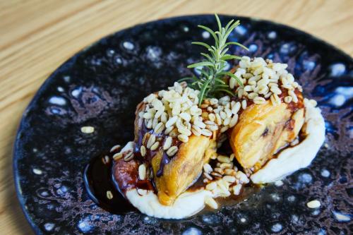 a black plate with food on a wooden table at Four Points by Sheraton Barcelona Airport in Barcelona