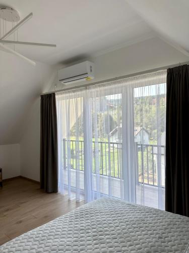 a bedroom with a bed and a large window at Апартаменти Velvet Rooms in Skhidnitsa