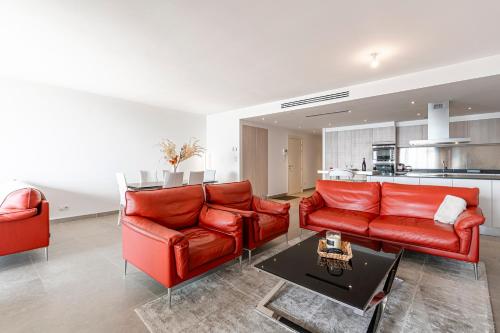 un salon avec deux canapés rouges et une cuisine dans l'établissement Agosta Bella - Appt en face de la plage dAgosta, à Albitreccia