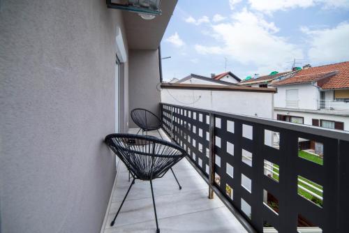 a balcony with two chairs on the side of a building at Urban Cozy Apartments Zagreb in Zagreb