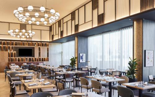 a restaurant with tables and chairs and a television at Four Points by Sheraton Barcelona Airport in Barcelona