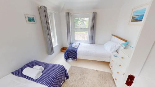 a small bedroom with two beds and a window at Georgeham Windsor Cottage 3 Bedrooms in Georgeham