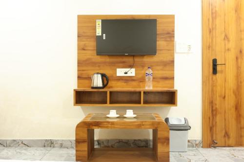 a room with a table with a tv on a wall at The Rajputana Palace in Phanda