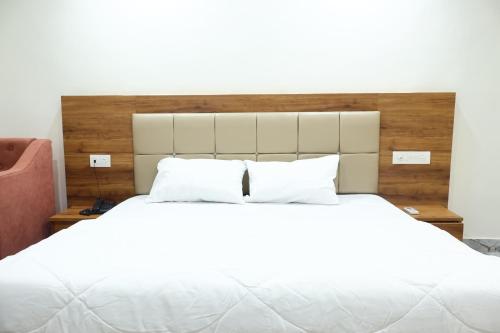 a bedroom with a large white bed with white pillows at The Rajputana Palace in Phanda
