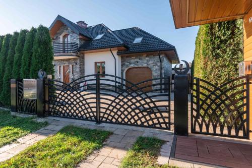 a gate in front of a house at Dream Holiday z Sauna i jacuzzi Lovely Krynica Zdrój in Florynka